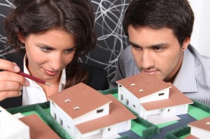 Two architect looking a miniature housing model